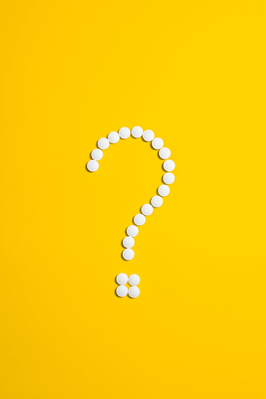A question mark made of tiny buttons on a yellow background.