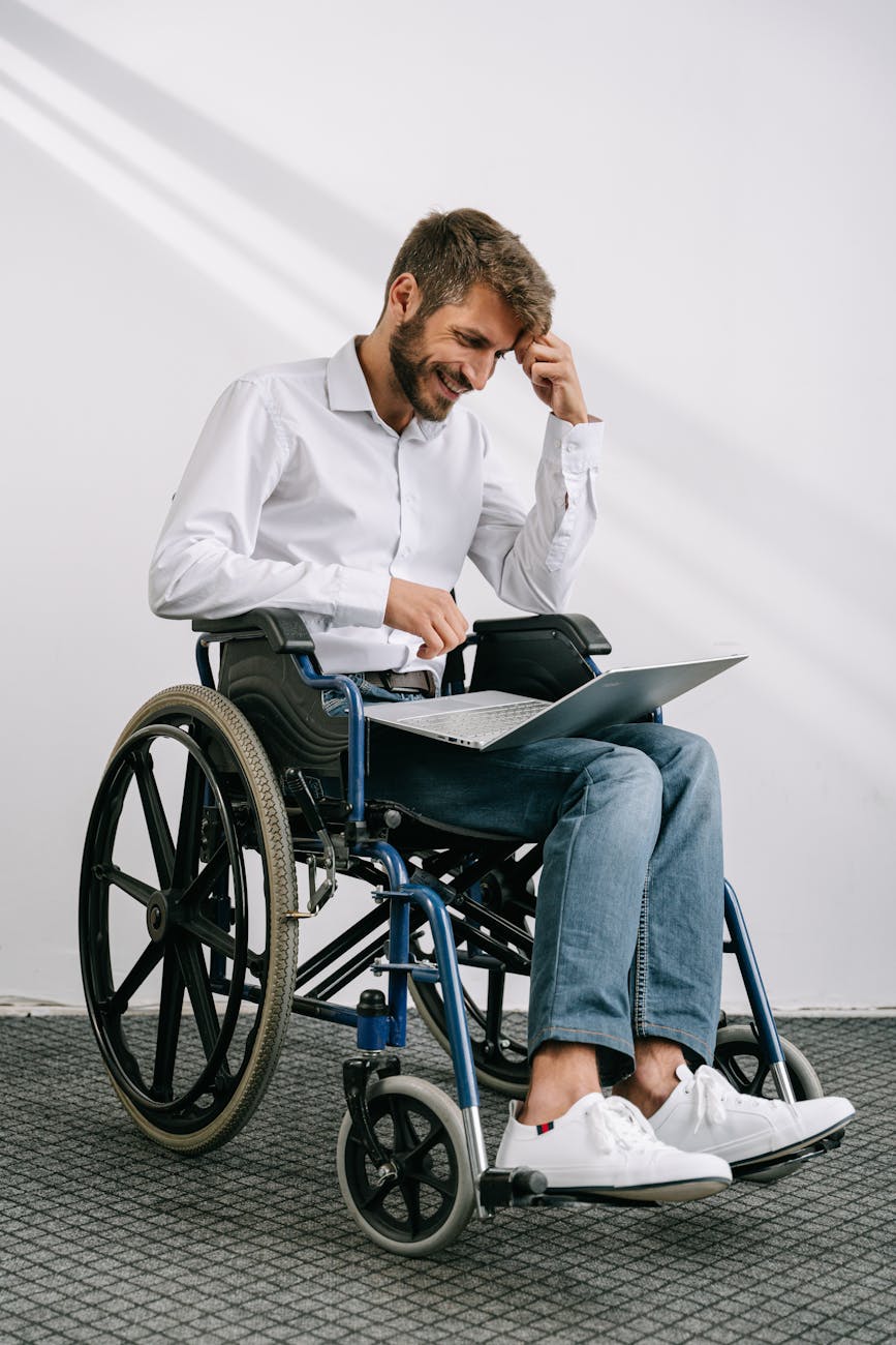 wheelchair bound worker uses chair to support laptop